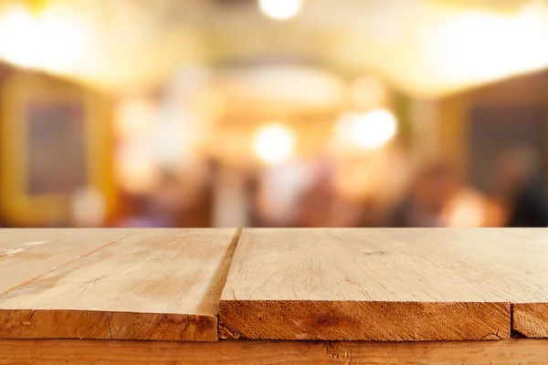 Table en bois vide et fond de café flou — Photo