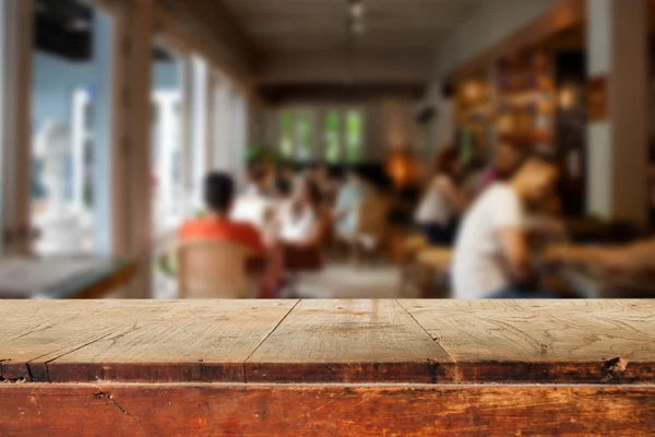 Lege houten tafel en wazig mensen in café achtergrond — Stockfoto