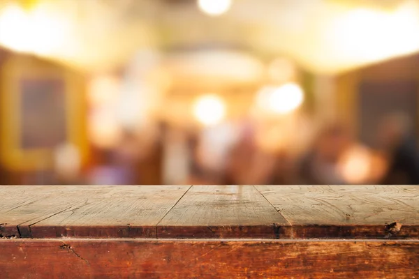 Table en bois vide et fond de café flou — Photo