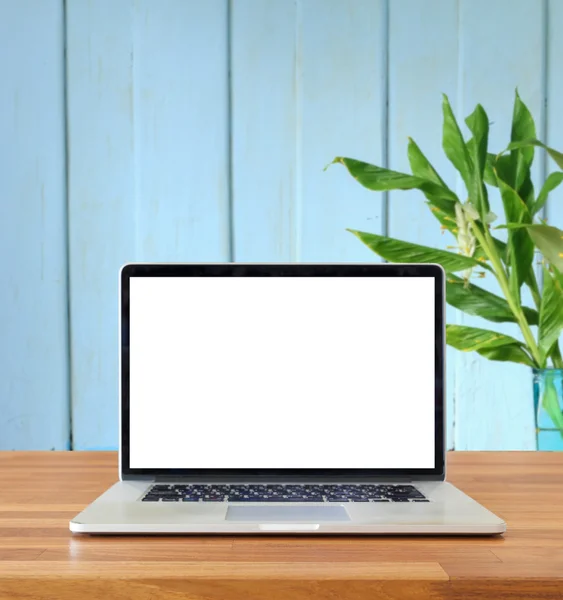 Masada mavi duvar ve çiçek arka plan üstünde laptop