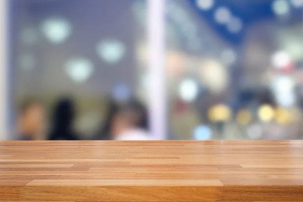 Mesa de madeira vazia e fundo café borrado — Fotografia de Stock