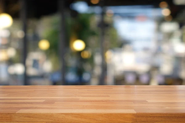 Table en bois vide et fond de café flou , — Photo