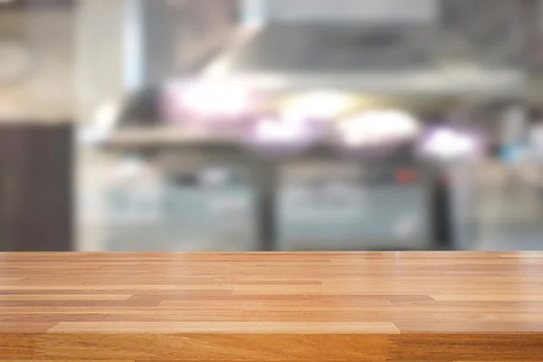Άδειο ξύλινο τραπέζι και φόντο θολή κουζίνα — Φωτογραφία Αρχείου