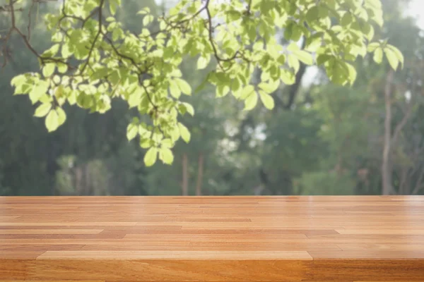 Bulanık ağaçlar arka plan üzerinde boş ahşap masa — Stok fotoğraf
