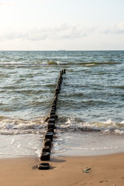 Dalgakıran deniz sahilinde ahşap direkleri bir satır