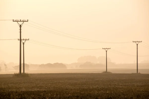 Por do sol sobre os campos na névoa — Fotografia de Stock