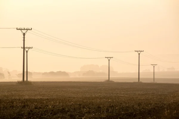 Zonsondergang over de velden in de mist — Stockfoto