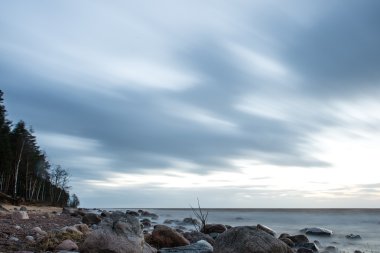 Kayalar ile bir plaj deniz kıyısında günbatımı