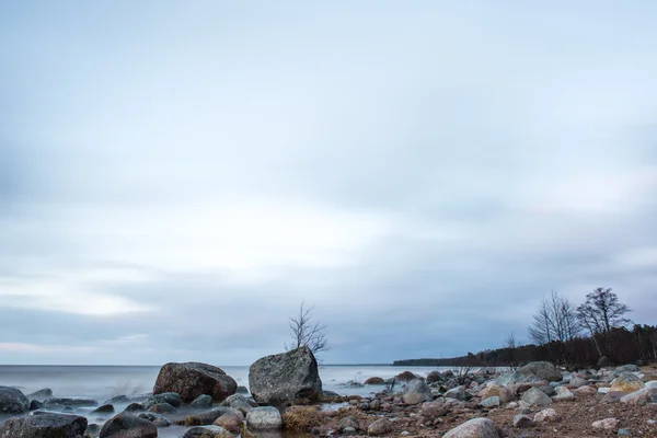 Naplemente a tenger partján egy strand sziklák — Stock Fotó