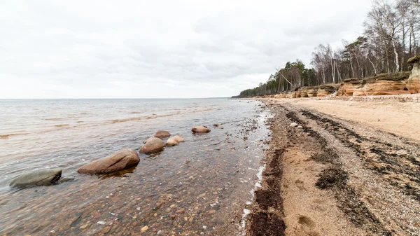 Rotsachtige herfst strand met golven op de rotsen — Stockfoto
