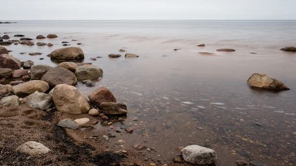 Playa rocosa de otoño con olas estrellándose en las rocas —  Fotos de Stock