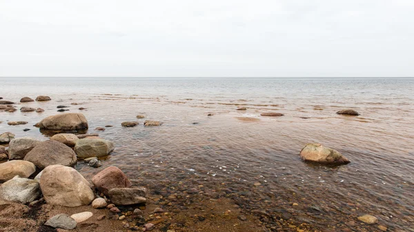 Őszi, sziklás strand található a hullámok összeomlik a sziklákon — Stock Fotó