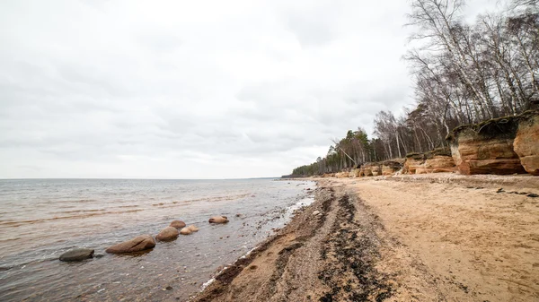 Rotsachtige herfst strand met golven op de rotsen — Stockfoto