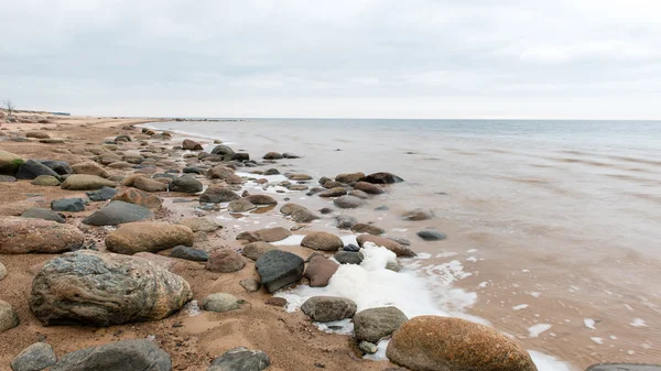Őszi, sziklás strand található a hullámok összeomlik a sziklákon — Stock Fotó
