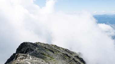 bulutlar ve sis kaplı kayalık dağ manzarası