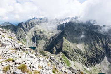 bulutlar ve sis kaplı kayalık dağ manzarası