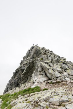 bulutlar ve sis kaplı kayalık dağ manzarası