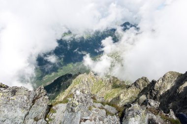 bulutlar ve sis kaplı kayalık dağ manzarası
