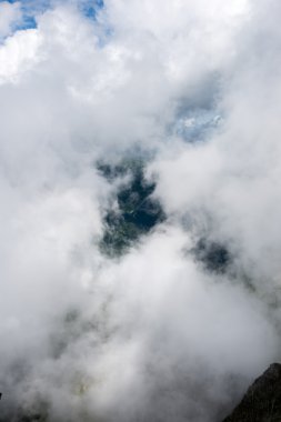 bulutlar ve sis kaplı kayalık dağ manzarası