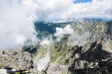 bulutlar ve sis kaplı kayalık dağ manzarası