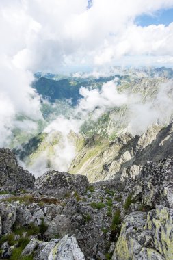 bulutlar ve sis kaplı kayalık dağ manzarası