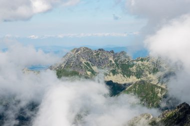 bulutlar ve sis kaplı kayalık dağ manzarası
