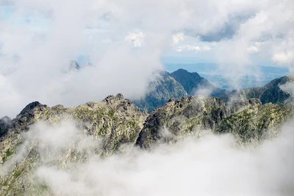 Paisaje rocoso de montaña cubierto de nubes — Foto de Stock