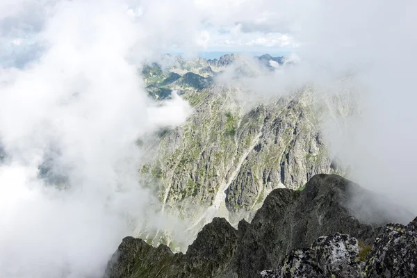 Klippiga bergslandskap täckt med moln — Stockfoto