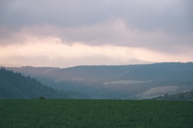 Karanlık fırtına bulutları yeşil çim - vintage etkisi ile çayır üzerinde