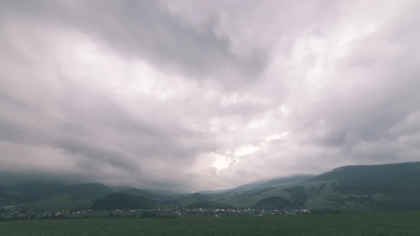 Nuvole di tempesta scure sul prato con erba verde effetto vintage — Foto Stock