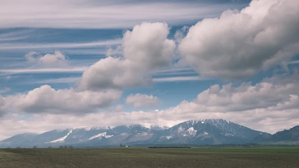 Ciemne chmury burzowe nad łąka z zielonej trawie - vintage efekt — Zdjęcie stockowe