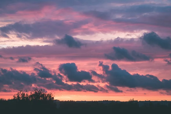 Nuages orageux rouges sur prairie avec herbe verte - effet vintage — Photo