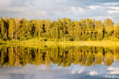 Mavi gökyüzü, kırmızı ve orangutan ile gölde güzel sonbahar günbatımı