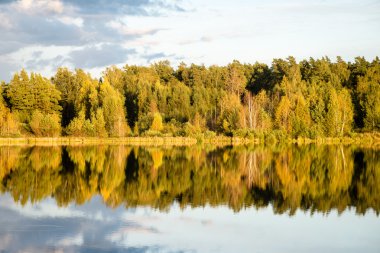 Mavi gökyüzü, kırmızı ve orangutan ile gölde güzel sonbahar günbatımı