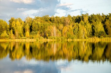 Mavi gökyüzü, kırmızı ve orangutan ile gölde güzel sonbahar günbatımı