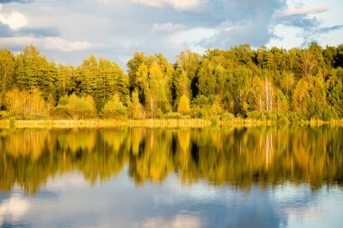 Mavi gökyüzü, kırmızı ve orangutan ile gölde güzel sonbahar günbatımı