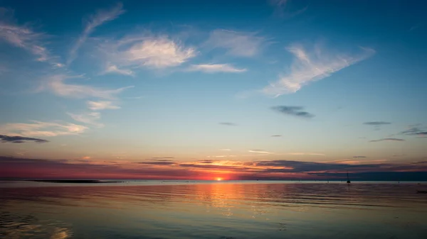 Bellissimo tramonto estivo al fiume con cielo blu, rosso e orano — Foto Stock