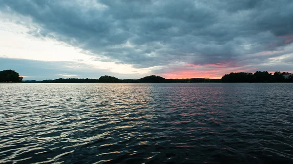 Dramatischer Sommersonnenuntergang am Fluss mit blauem Himmel, Rot und Orang-Utan — Stockfoto