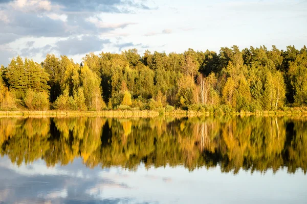 Mavi gökyüzü, kırmızı ve orangutan ile gölde güzel sonbahar günbatımı