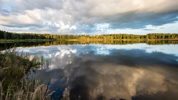 Mooie zomerse zonsondergang aan het meer met blauwe hemel, rood en orang — Stockfoto