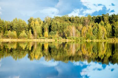 Mavi gökyüzü, kırmızı ve orangutan ile gölde güzel sonbahar günbatımı