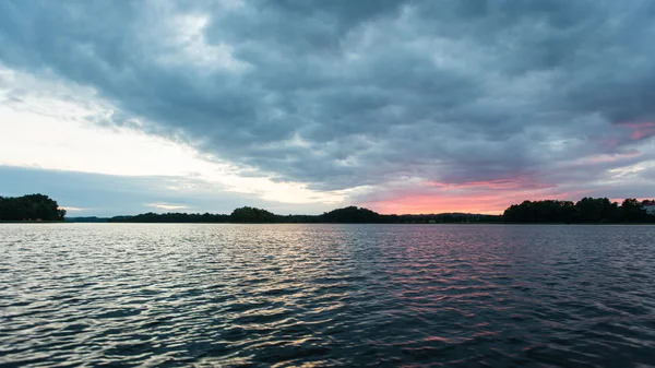 Dramatisk sommar solnedgång vid floden med blå himmel, röd och orang — Stockfoto