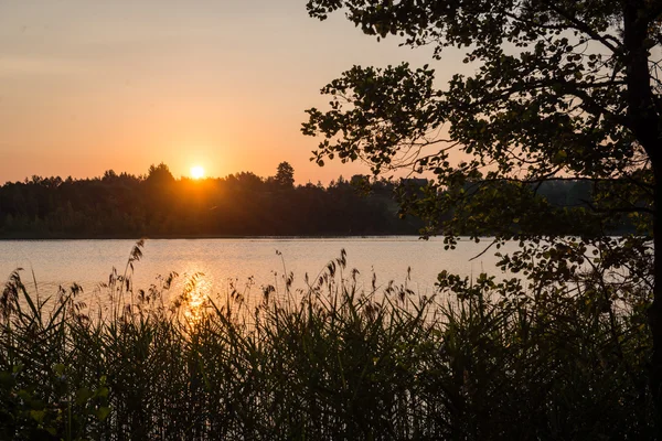 Beau coucher de soleil d'été au bord du lac avec ciel bleu, rouge et orang — Photo