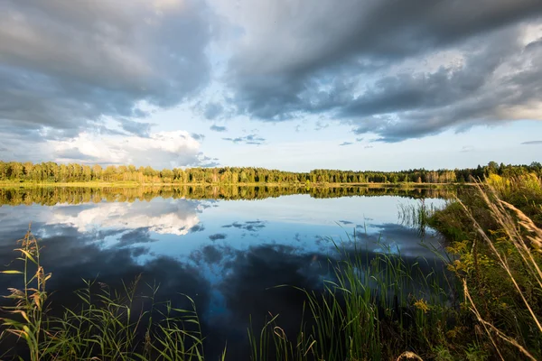 Mooie zomerse zonsondergang aan het meer met blauwe hemel, rood en orang — Stockfoto