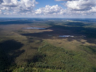 Yazın bulutlu gökyüzünün altında yollar ve yeşil alanlar olan kırsal hava manzarası