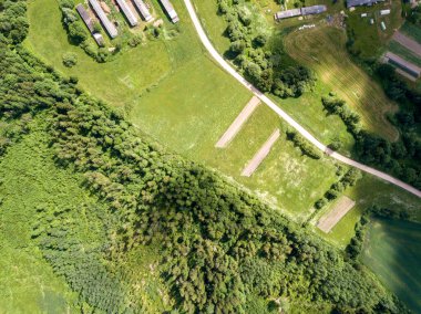 Yazın bulutlu gökyüzünün altında yollar ve yeşil alanlar olan kırsal hava manzarası