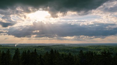 Tarlaların ve şehirlerin üzerinde dramatik, kırmızı, karanlık, dramatik bulutlar var.