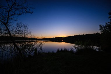 Tarlaların ve şehirlerin üzerinde dramatik, kırmızı, karanlık, dramatik bulutlar var.