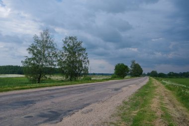 Gökyüzünde toz ve güneş ışınları olan sonsuz güzel taşra yolu. Geleceği gezmek