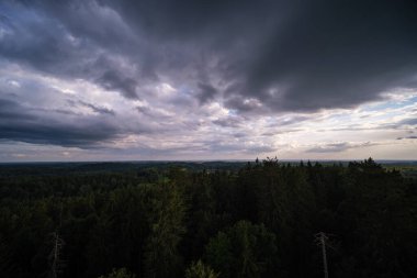Tarlaların ve şehirlerin üzerinde dramatik, kırmızı, karanlık, dramatik bulutlar var.